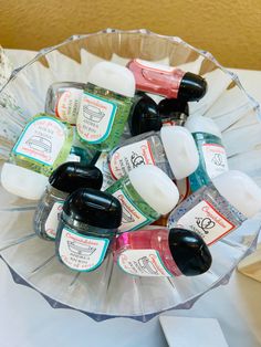 a glass bowl filled with lots of different types of skin care products on top of a table