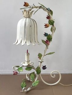 a white lamp with flowers and leaves on it