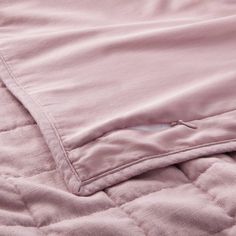 a close up view of the pocket on a pink quilted jacket with zippers