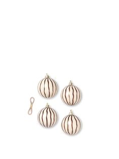 three white and brown striped ornaments on a white surface with a pair of scissors next to them