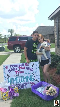 a man and woman standing in front of a welcome home sign with a cat on it