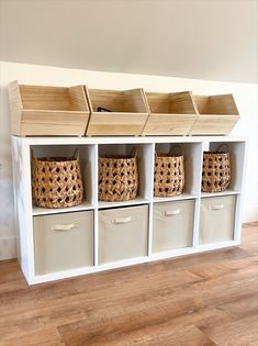 a white shelf with baskets and bins on it