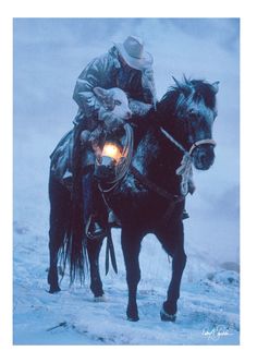 a man riding on the back of a black horse in the middle of snow covered ground