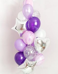 purple and white balloons are arranged in a vase