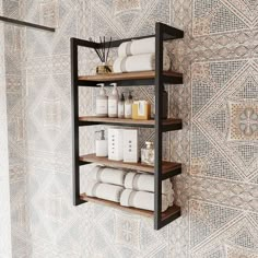 a shelf with towels and other items on it in front of a wallpapered background