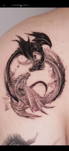 a dragon tattoo on the back of a woman's shoulder