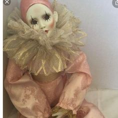 the doll is wearing a pink and gold outfit