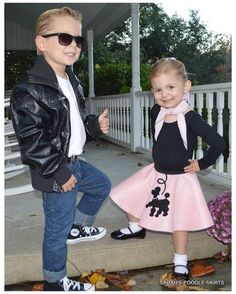 two young children dressed in costumes posing for a photo on the front steps of a house