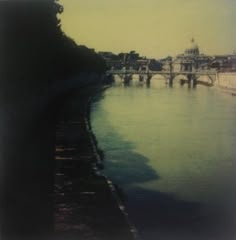 an old photo of a bridge over a body of water