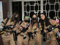 four women dressed in costumes and masks posing for the camera