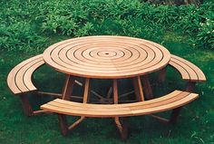 three wooden benches sitting on top of a lush green field