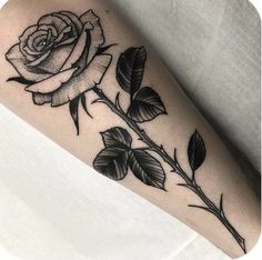 a black and white rose tattoo on the arm