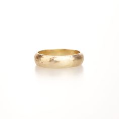 a gold wedding ring on a white background, with the band slightly curled in half