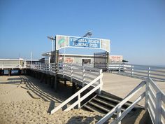 there is a sign that says virginia beach fishing club on the pier next to the ocean