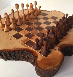 a wooden chess set on top of a piece of wood