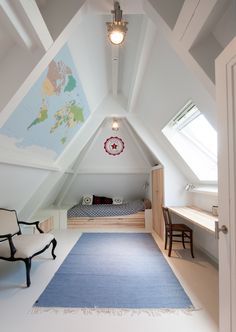 an attic bedroom with a blue rug and white walls, along with a bed in the corner