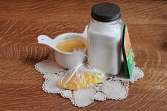 a table topped with a bottle of milk and some candies on top of a doily