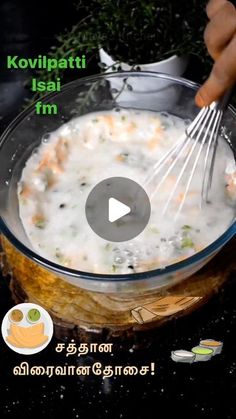 a bowl filled with food and whisks being stirred by a person's hand