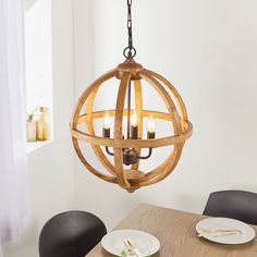 a wooden chandelier hanging over a dining room table with plates and utensils