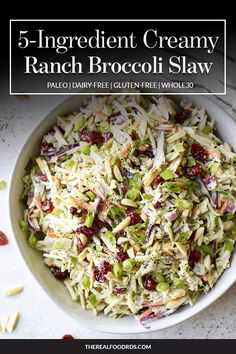 a bowl filled with coleslaw and cranberries on top of a table