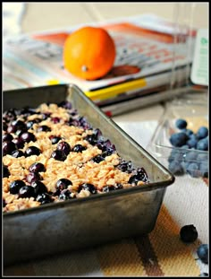 a pan filled with blueberries and oatmeal sitting on top of a table