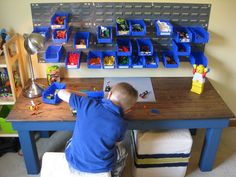 a young boy playing with toys at a table