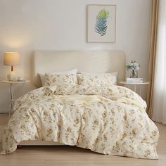 a bed with white sheets and yellow flowers on it in a room next to a window