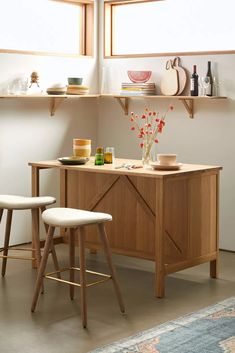 two stools sit in front of a table with plates and bowls on it,