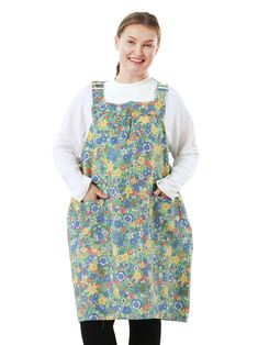 a woman wearing an apron and smiling at the camera with her hands on her hips