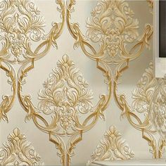 the wallpaper is gold and white with an intricate design on it's side