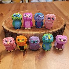 a group of small colorful owls sitting on top of a wooden table