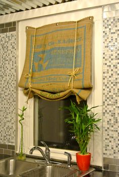 a kitchen sink under a window covered in burlock