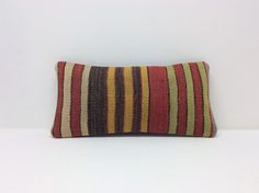 a striped pillow sitting on top of a white table