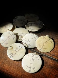 some white buttons with writing on them and a pair of scissors in the middle one