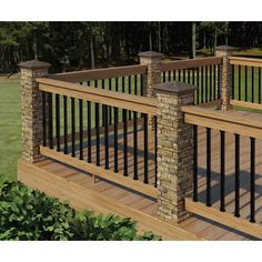 a wooden deck with black iron railings and brick pillars