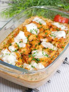 a casserole dish with meat and cheese in it on a table next to tomatoes