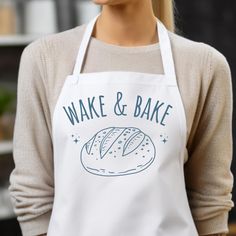 a woman wearing an apron that says wake and bake with a loaf of bread on it