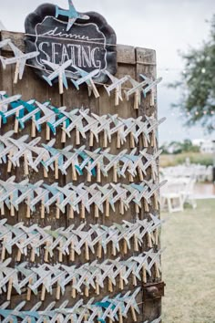 a wooden sign that says seating on it and some clothes pins attached to the board