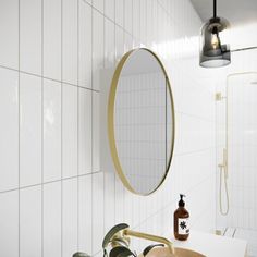 a bathroom with white tiles and gold fixtures