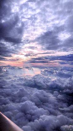 the view from an airplane looking down on clouds