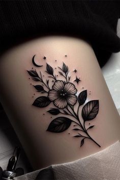 a woman's thigh with flowers and stars on the side, in black ink