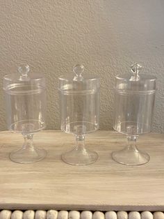 three clear glass dishes on top of a wooden table