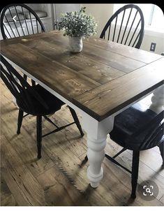 a dining room table with two chairs and a potted plant on top of it