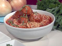 a white bowl filled with spaghetti and meatballs