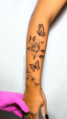 a woman's arm with flowers and butterflies on it