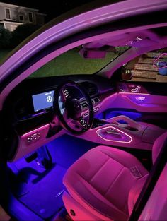 the interior of a car is lit up with pink and blue lights