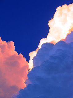 an airplane is flying in the sky with clouds and blue skies behind it at sunset