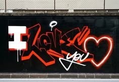 graffiti on the side of a building with red and white spray paint in the shape of a heart