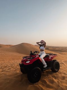 a woman is riding an atv in the desert