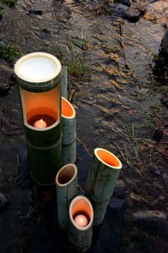 three candles are sitting in the middle of some trash canisters on the ground